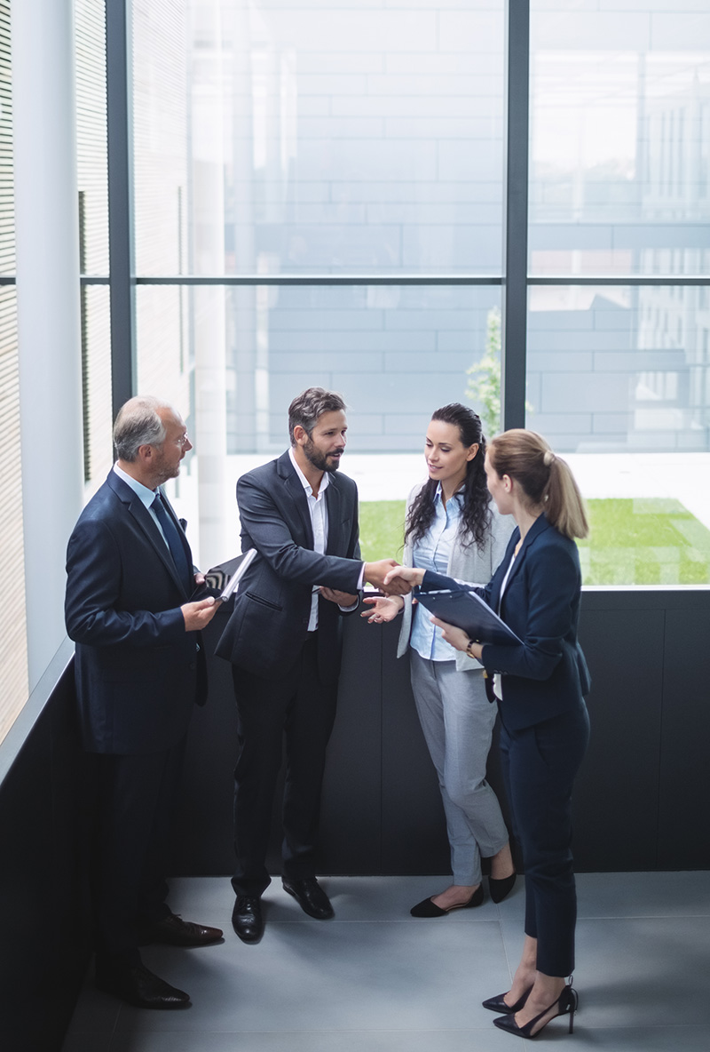 Group of businesspeople having a discussion near staircase in office