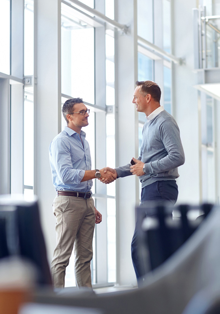 Business people, handshake or greeting in hotel lobby, modern of